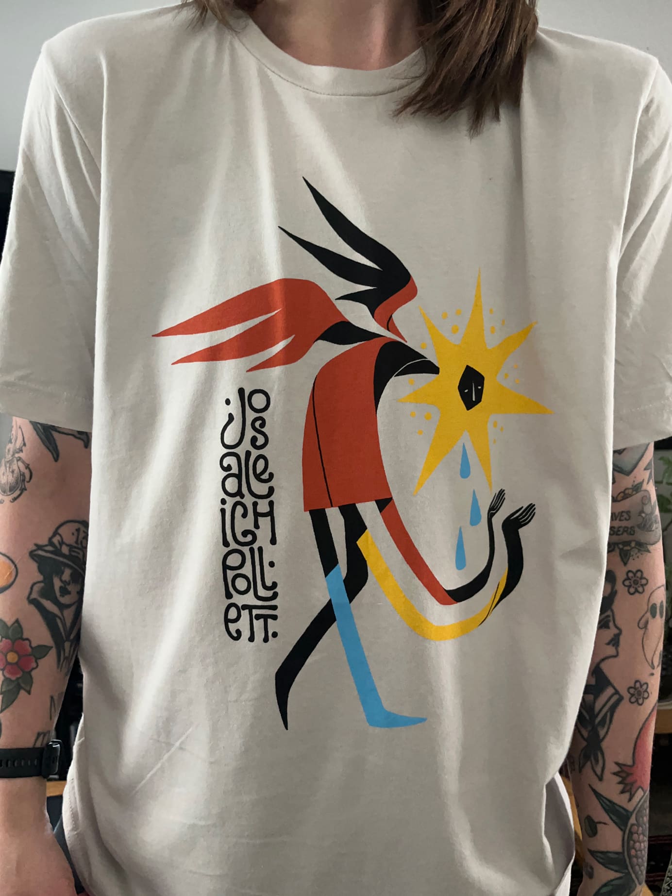A t-shirt made for Josaleigh Pollett. A brightly colored, abstracted angel walks and weeps into their hands.