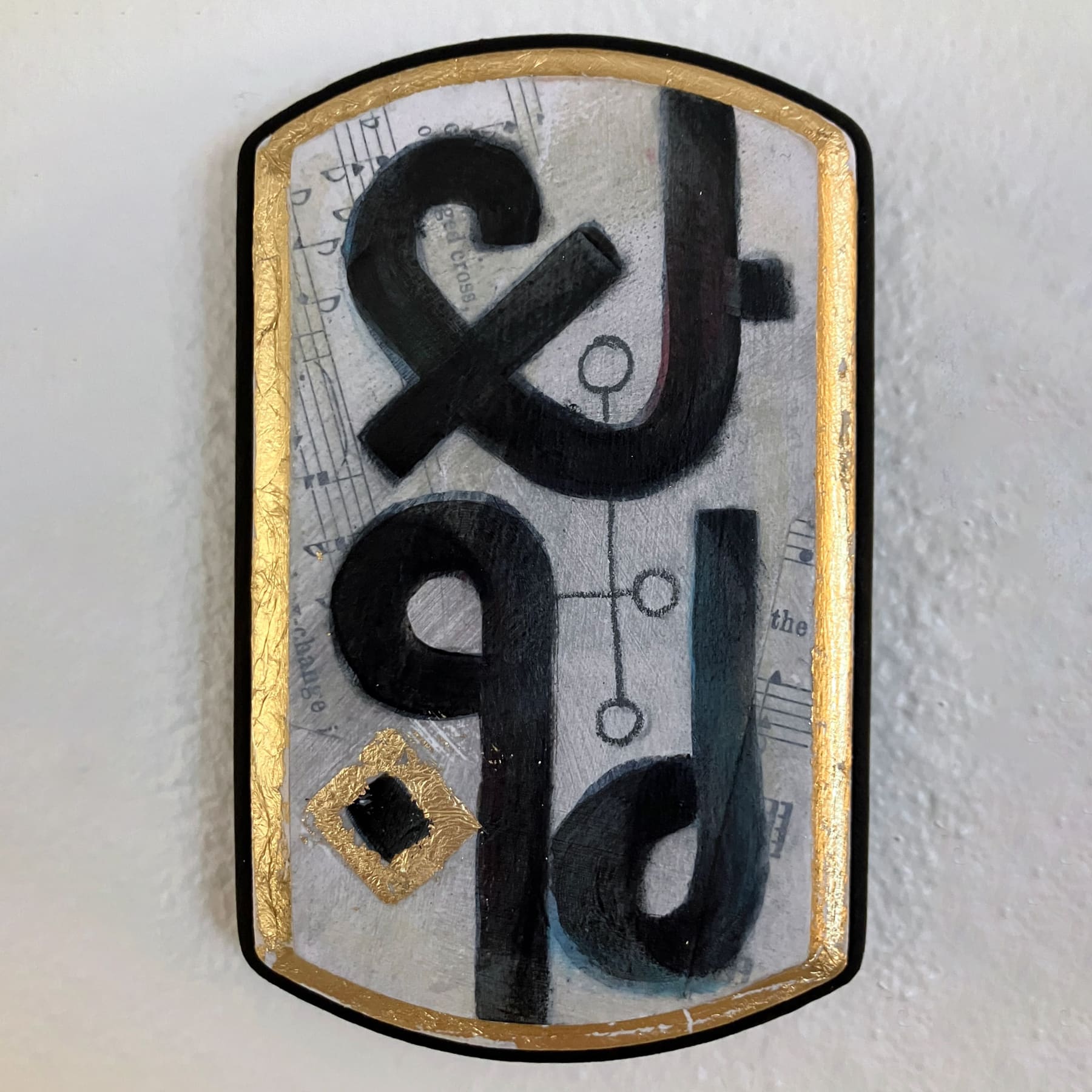 A Wormrōte sigil meaning 'patience' is highlighted with a diamond in gold leaf. A faint collage of hymns and pencil sigils are scattered in the background, and the edges of the panel are gilt in gold leaf.